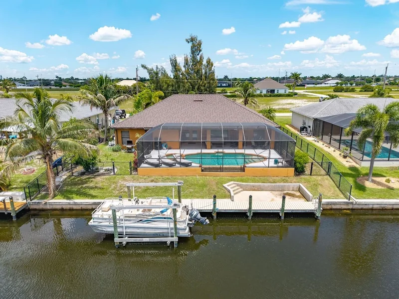 Waterfront home with a screened pool, dock and boat