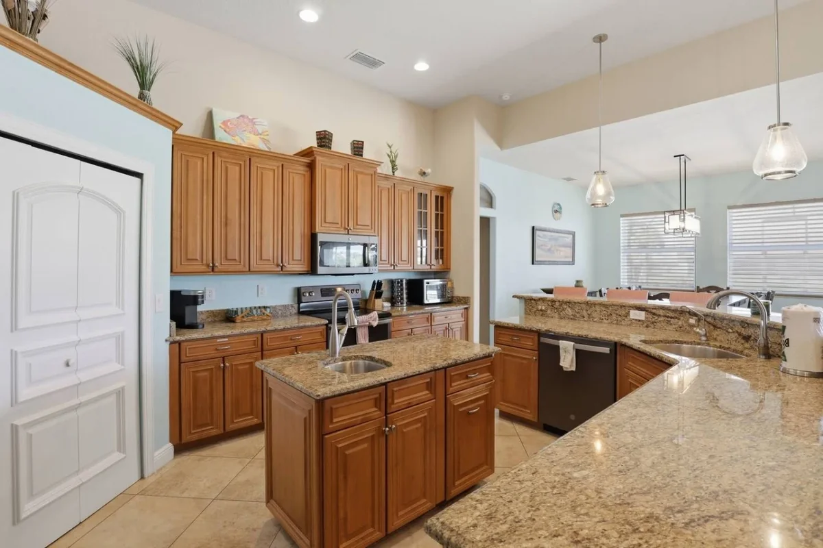 Cape Coral villa kitchen with wood cabinets, an island and stainless steel appliances